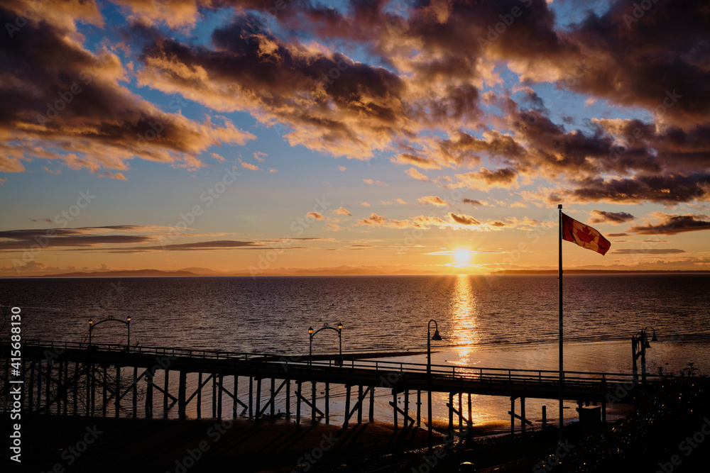 Spectacular sunset at White Rock pier with Canada flag