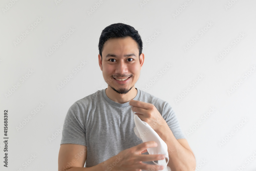 Asian man is showing off his mask and how to wear it on isolated background. Asian man is showing off his mask and how to wear it on isolated background.