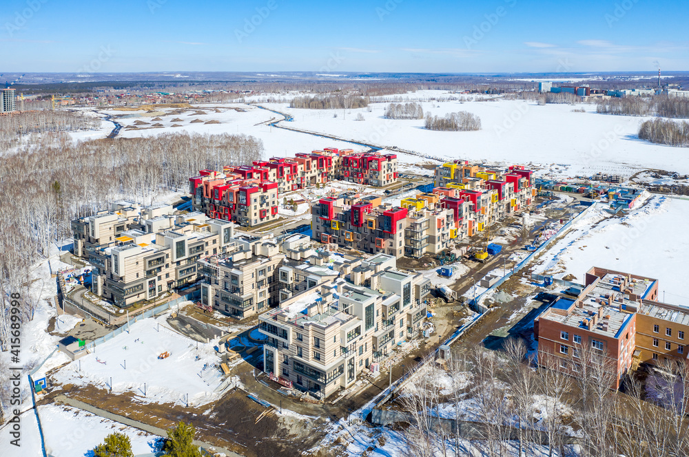 Aerial view of a low-rise rural district in Koltsovo, Russia, in the middle of the snowy expanses of Siberia in Sunny weather