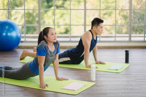 Adult asian man and woman family wearing sport outfit do exercise workout yoga for healthy self care at home