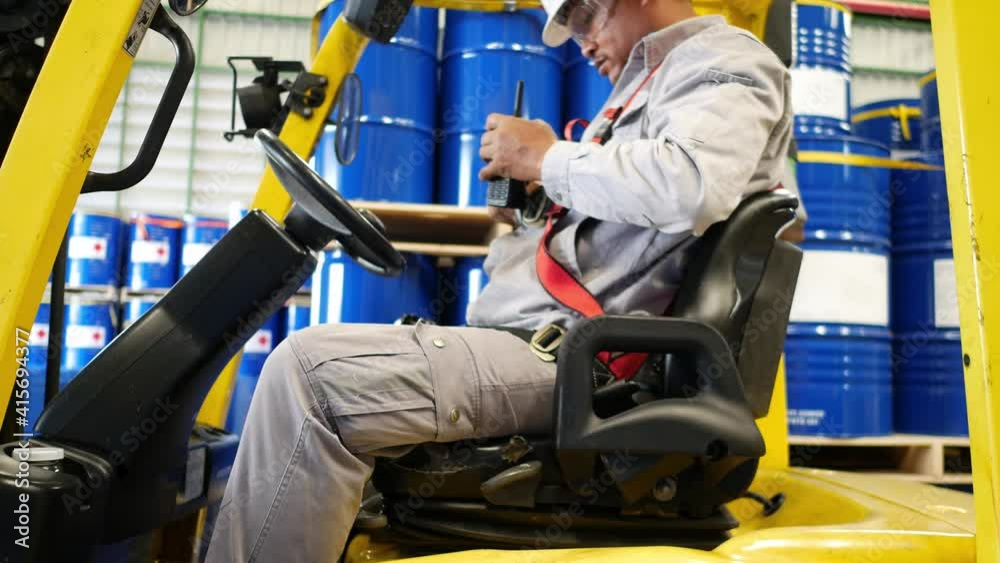 The forklift driver inside the chemical depot is checking the condition of the car before using it every day. The forklift driver inside the chemical depot is checking the condition of the car before using it every day.