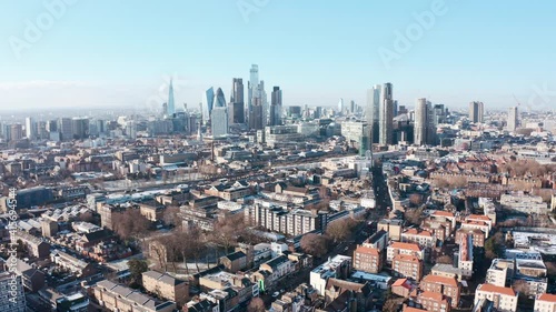 rising high drone shot over city of london skyscrapers from tower hamlets clear day after snow photo