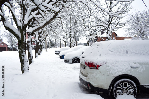 parked cars covered with snow near the road. Cityscape.