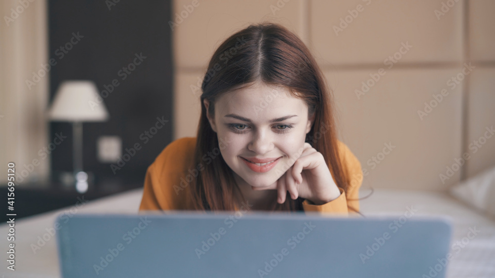 pretty cheerful woman lies in bed in front of laptop internet pretty cheerful woman lies in bed in front of laptop internet
