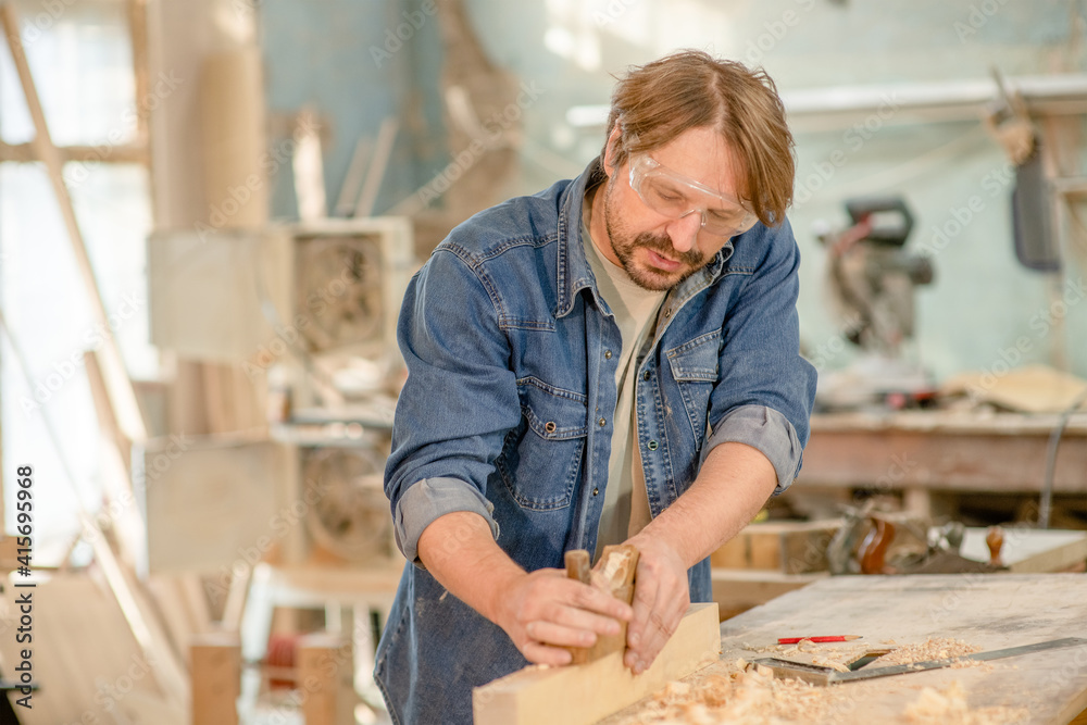 Man planed wood in the carpentry shop Man planed wood in the carpentry shop