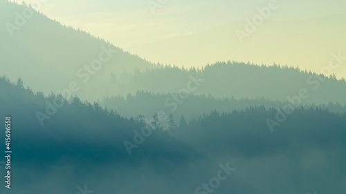 Mountain layers during sunrise in foggy morning. British Columbia, Canada.