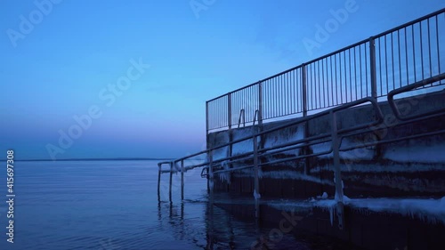 An ice-covered bathing ramp and small pier on a Norwegian beach photo