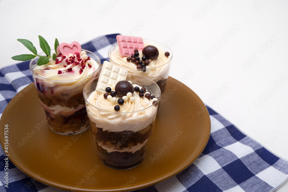Trifles portioned mini cakes on plate. Layered trifle dessert with whipped cream and chocolate Trifles portioned mini cakes on plate. Layered trifle dessert with whipped cream and chocolate