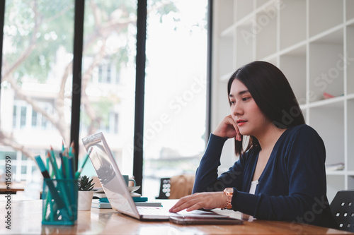 Young asian business woman working in coffee shop or cafe.