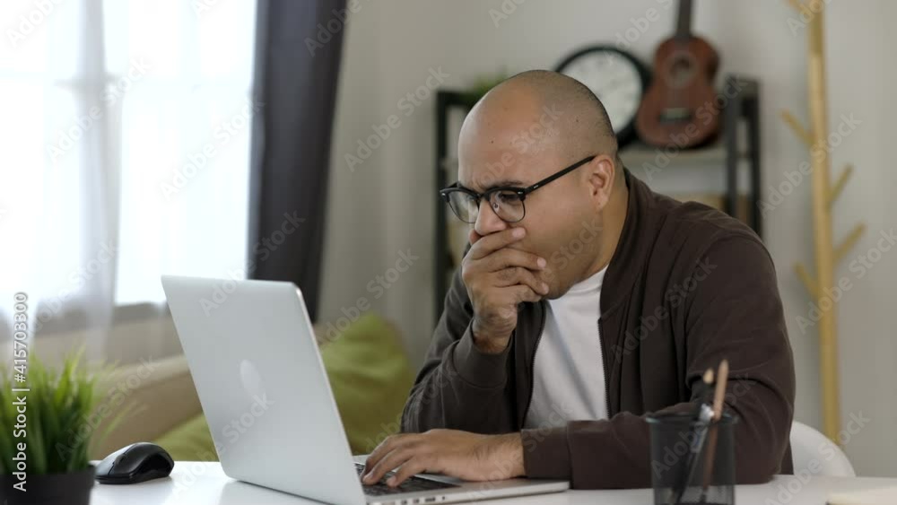 Tired businessman working with laptop. He covered his mouth with his hand and yawned. He is very sleepy. He work from home.
Tired businessman working with laptop. He covered his mouth with his hand and yawned. He is very sleepy. He work from home.