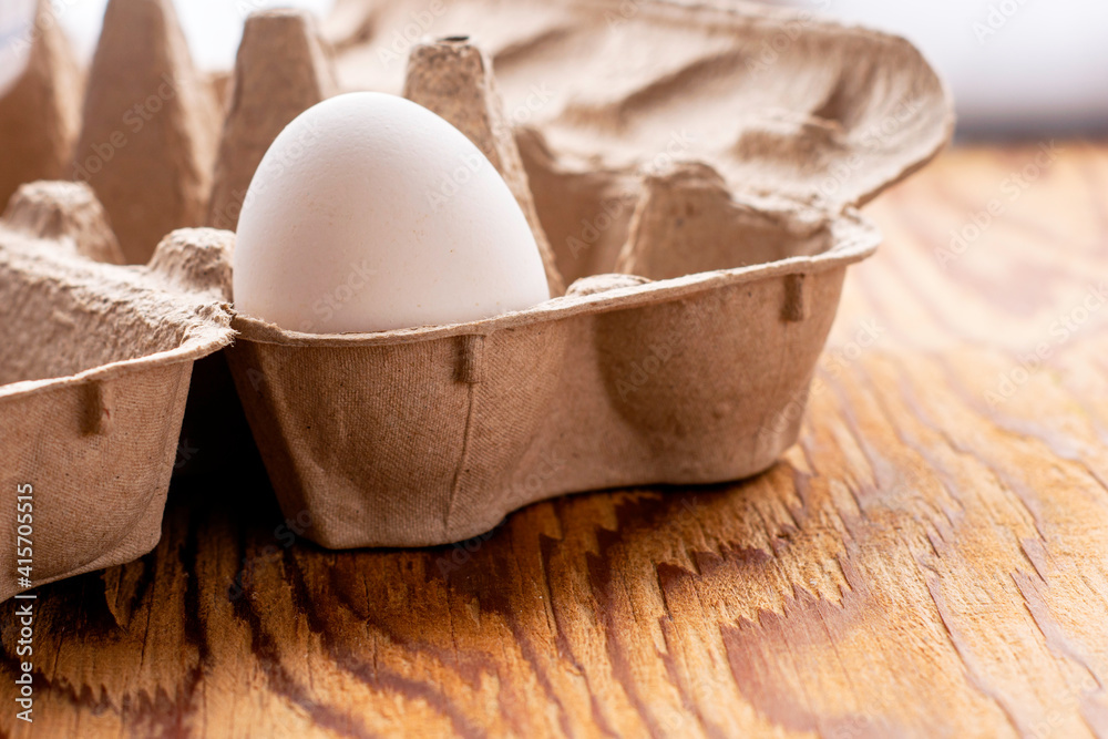 one white chicken egg is in a package on the table one white chicken egg is in a package on the table