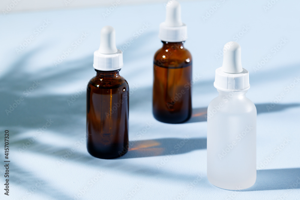 Glass jar with skincare liquid on gray background with shadow Glass jar with skincare liquid on gray background with shadow