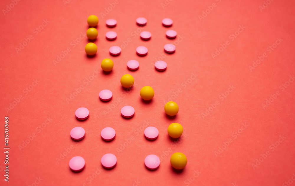 multicolored pills on red background medicine health