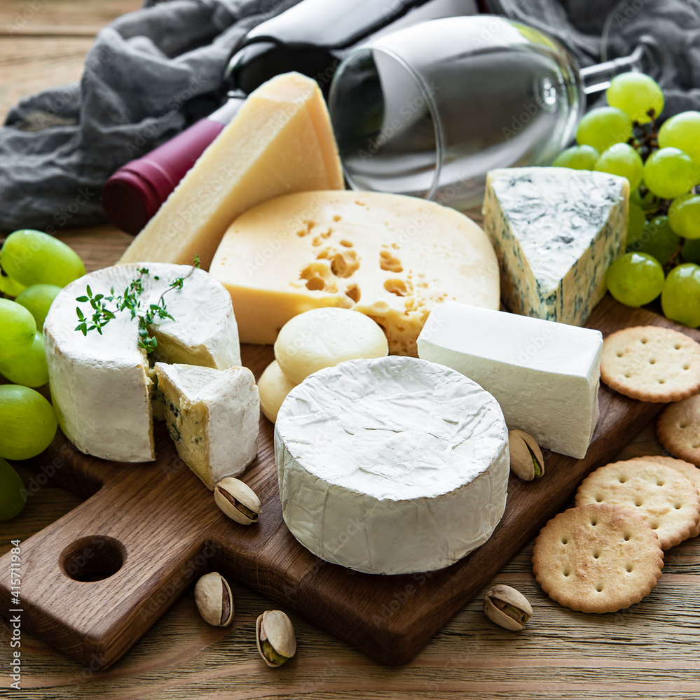 Various types of cheese, grapes and wine