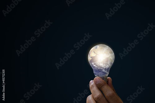 Fototapeta Naklejka Na Ścianę i Meble -  Ecological energy and idea concepts. Light bulb in hand, Hand holding light blue earth bulb. Elements of this image furnished by NASA