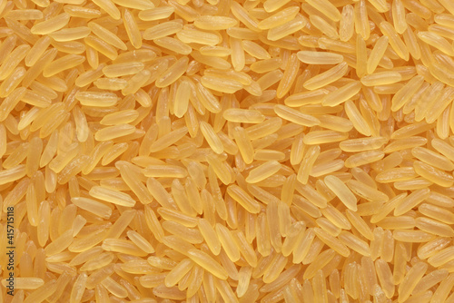 Parboiled yellow rice background or texture.