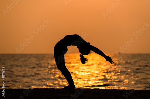 Sport woman yogini pose practice yoga exercise on sand beach near coconut palms in relaxing day , yoga is meditation and healthy sport concept