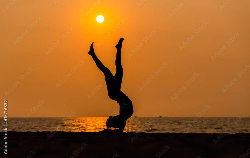 Sport woman yogini pose practice yoga exercise on sand beach near coconut palms in relaxing day , yoga is meditation and healthy sport concept