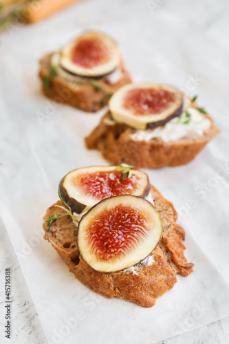 Tasty sandwiches with fig on parchment