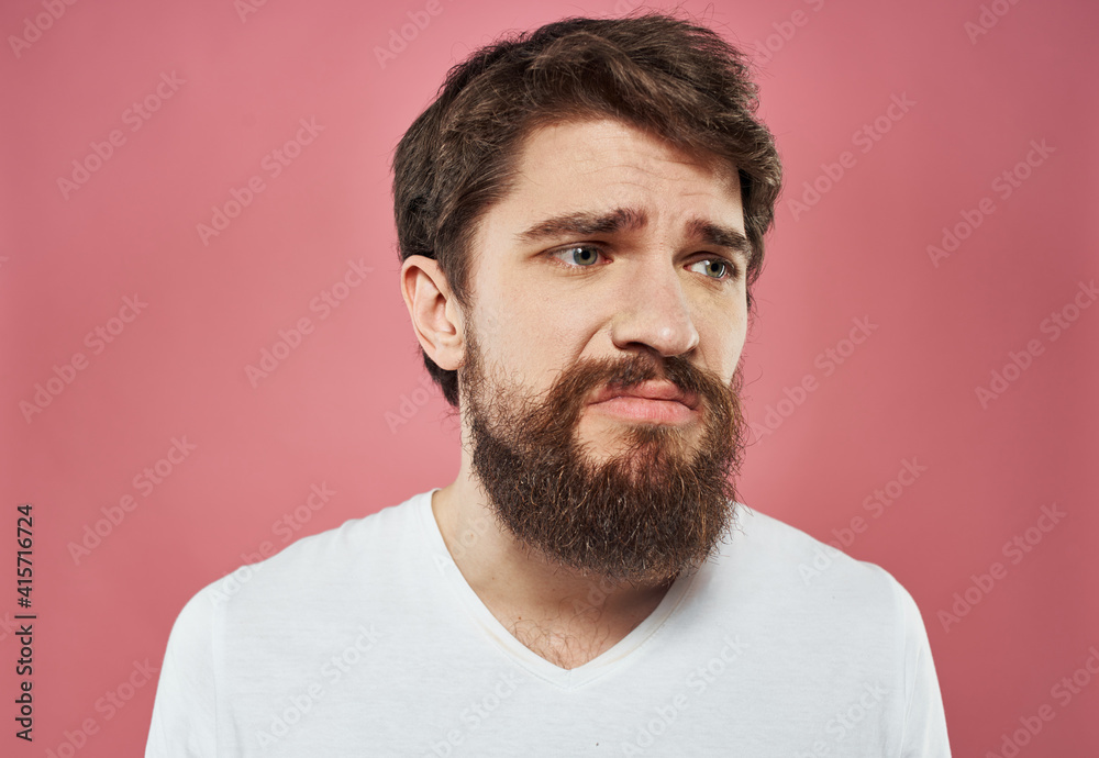 Portrait of a man with a thick beard white t-shirt brunette model close-up Portrait of a man with a thick beard white t-shirt brunette model close-up