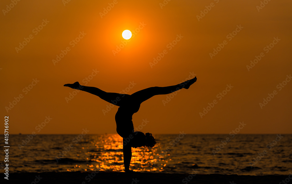 Silhouette sport woman pose practice yoga exercise on sand beach in morning , yoga is meditation heathy sport concept.