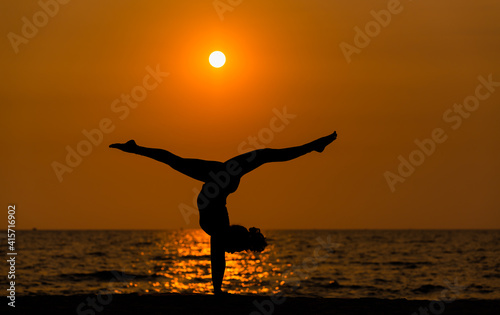 Silhouette sport woman pose practice yoga exercise on sand beach in morning   yoga is meditation heathy sport concept.