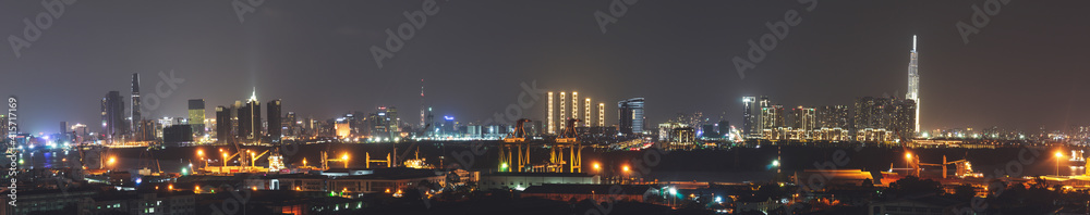 Aerial panoramic cityscape view of Ho Chi Minh city and the River Saigon, Vietnam with beautiful lights at night. Financial and business centers in developed Vietnam
