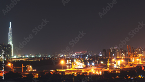 Aerial panoramic cityscape view of Ho Chi Minh city and the River Saigon, Vietnam with beautiful lights at night. Financial and business centers in developed Vietnam