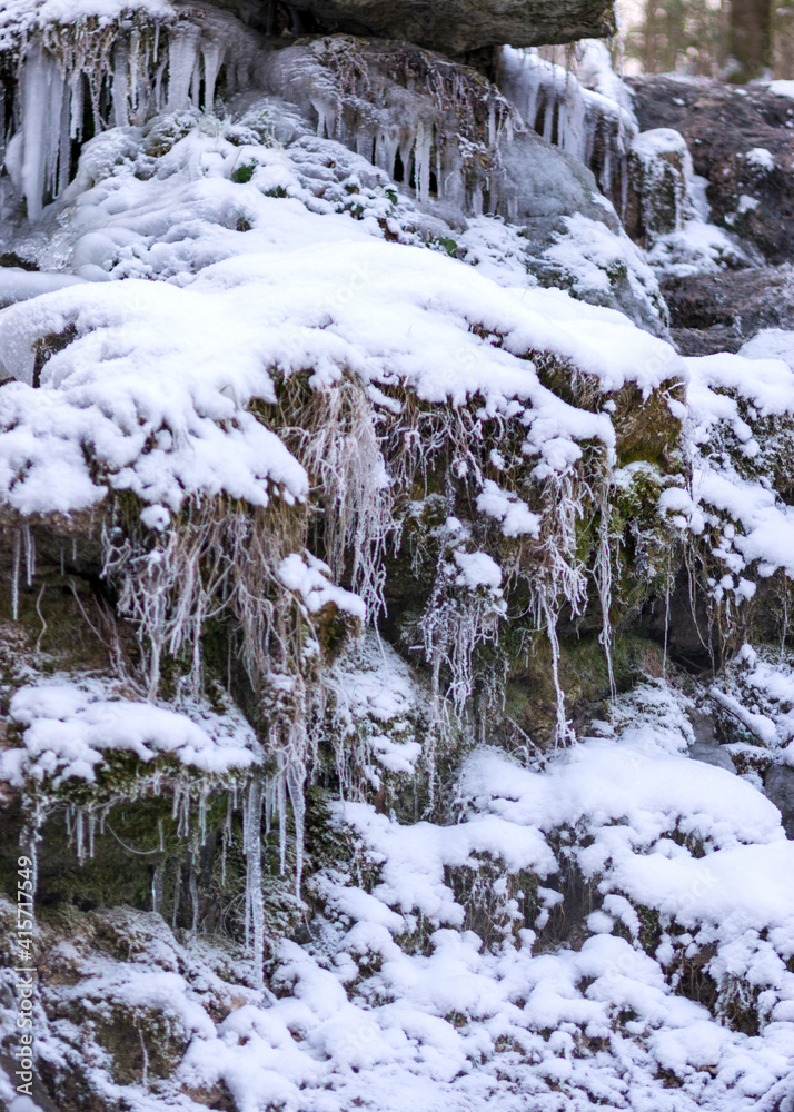 frozen fast flowing spring water, icy rocks and water stream, frosty tree roots, beautiful ice and water texture frozen fast flowing spring water, icy rocks and water stream, frosty tree roots, beautiful ice and water texture