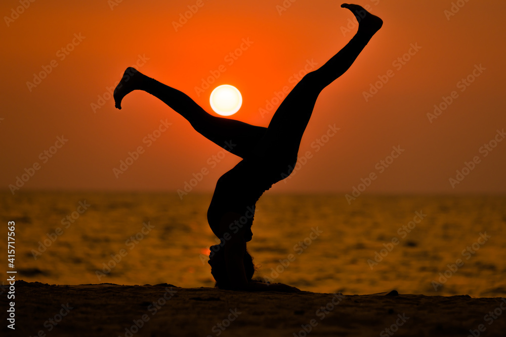 Silhouette sport woman pose practice yoga exercise on sand beach in morning , yoga is meditation heathy sport concept.