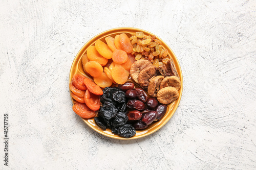 Fototapeta Naklejka Na Ścianę i Meble -  Plate with different dried fruits on light background