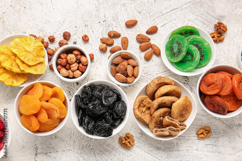 Fototapeta Naklejka Na Ścianę i Meble -  Bowls with different dried fruits and nuts on light background