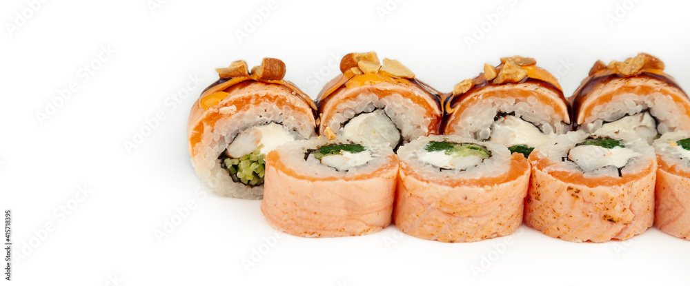 Sushi Roll with salmon tataki and blanched spinach on white plate, ingredients Salmon, shrimp, blanched spinach, cream cheese, cucumber, Spicy sauce, Teriyaki sauce, cashews, rice, nori. Sushi Roll with salmon tataki and blanched spinach on white plate, ingredients Salmon, shrimp, blanched spinach, cream cheese, cucumber, Spicy sauce, Teriyaki sauce, cashews, rice, nori.