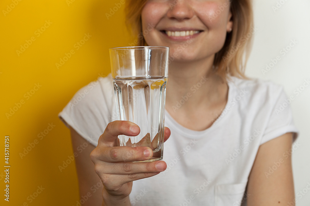 glass of clean drinking water in female beautiful hands. Beautiful young blonde girl with a glass of vodzha in her hands glass of clean drinking water in female beautiful hands. Beautiful young blonde girl with a glass of vodzha in her hands