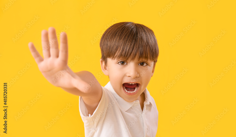Cute little boy waving hand on color background Cute little boy waving hand on color background