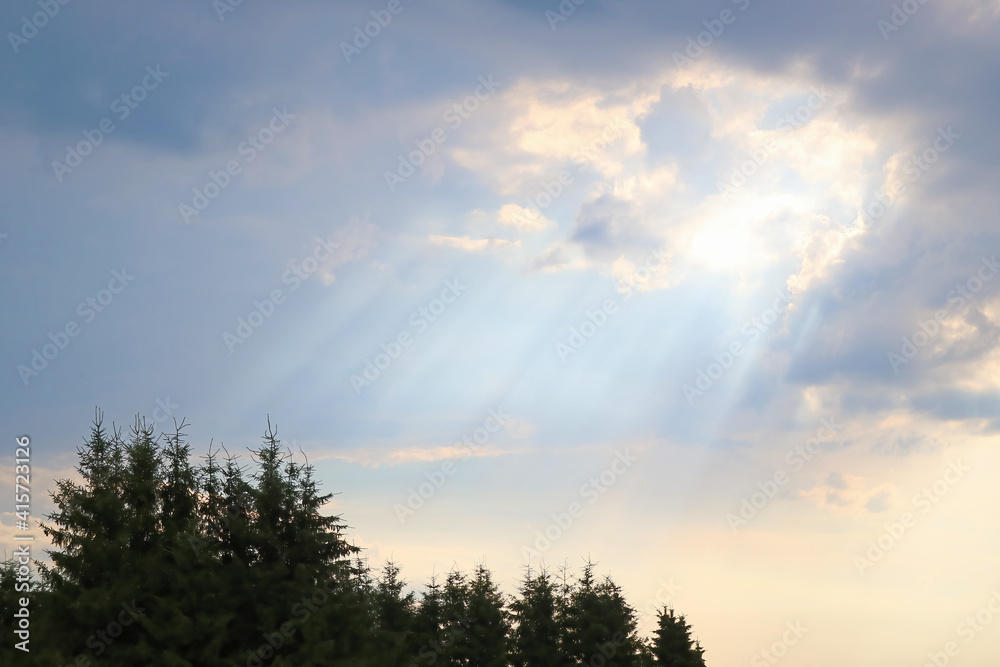 Light shines from behind a dark cloud after rain. Light shines from behind a dark cloud after rain.