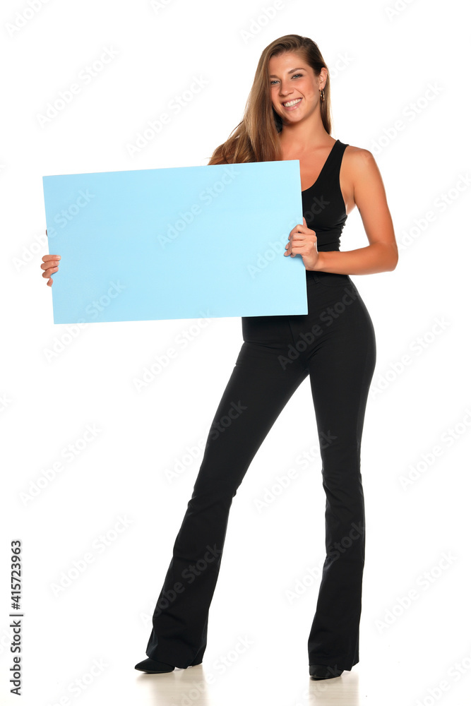 a young advertizing smiling woman in pants and a shirt holds empty board a young advertizing smiling woman in pants and a shirt holds empty board