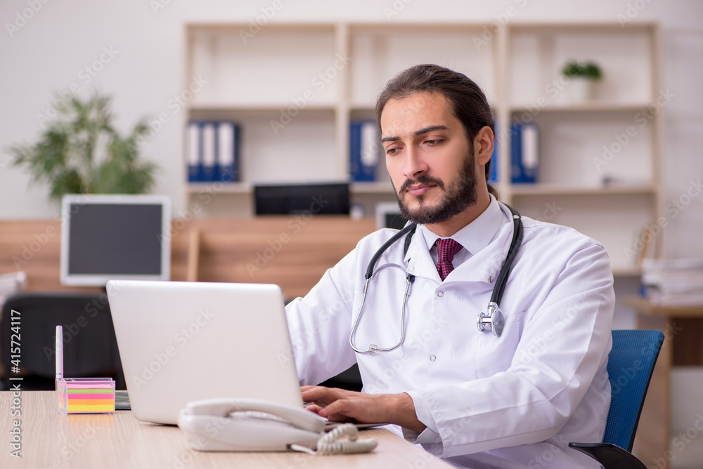 Young male doctor sitting in the office Young male doctor sitting in the office