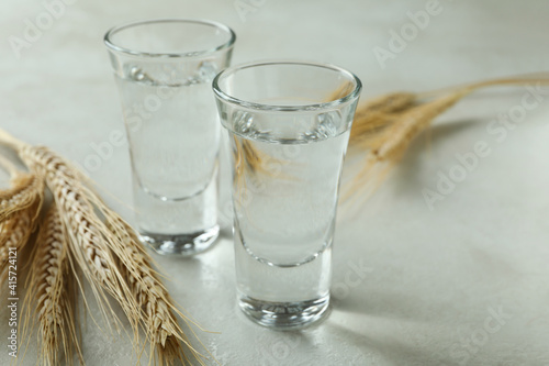 Shots of vodka and spikelets on white textured table