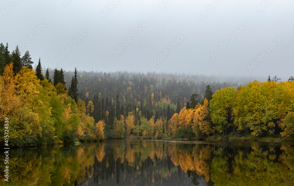 Beautiful reflection of autumn colors on river surface during autumn foliage at Finnish Lapland near Kuusamo
