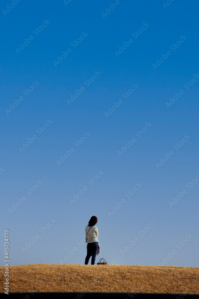 綺麗な青空と公園で散歩している若い女性の姿 綺麗な青空と公園で散歩している若い女性の姿
