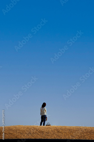 綺麗な青空と公園で散歩している若い女性の姿 © zheng qiang