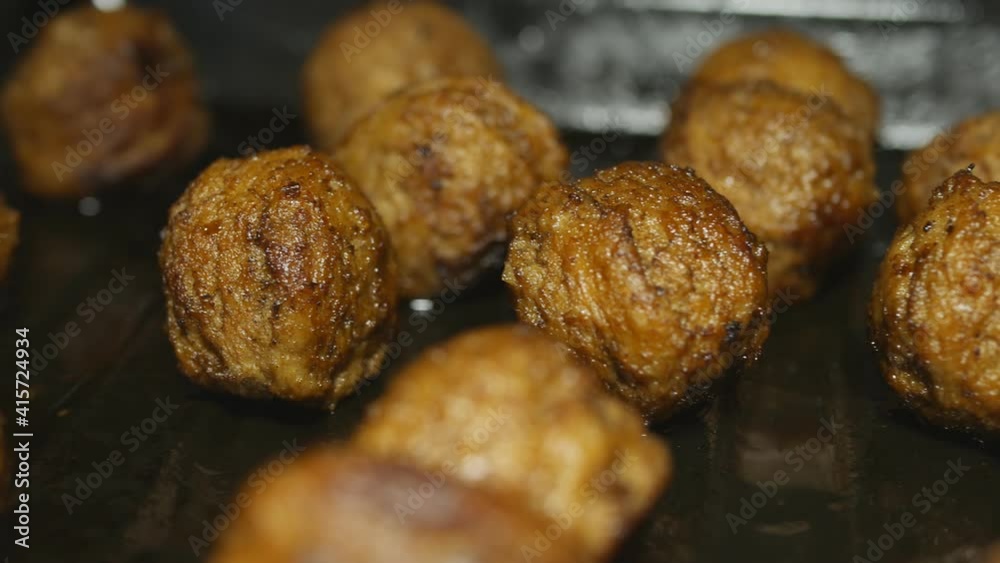 fried meatballs on a baking sheet are illuminated by a movement of light in the dark. Shadows change. Dolly shooting. Close-up fried meatballs on a baking sheet are illuminated by a movement of light in the dark. Shadows change. Dolly shooting. Close-up