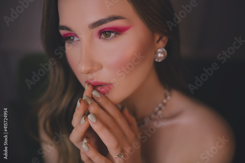 Close up portrait of young beautiful woman with creative holiday makeup.