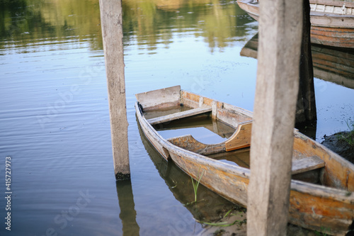 Half sunken wooden boat is moored to the shore