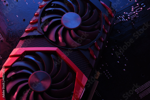 Computer game graphics card  videocard with two coolers on circuit board  motherboard background. Close-up. With red-blue lighting