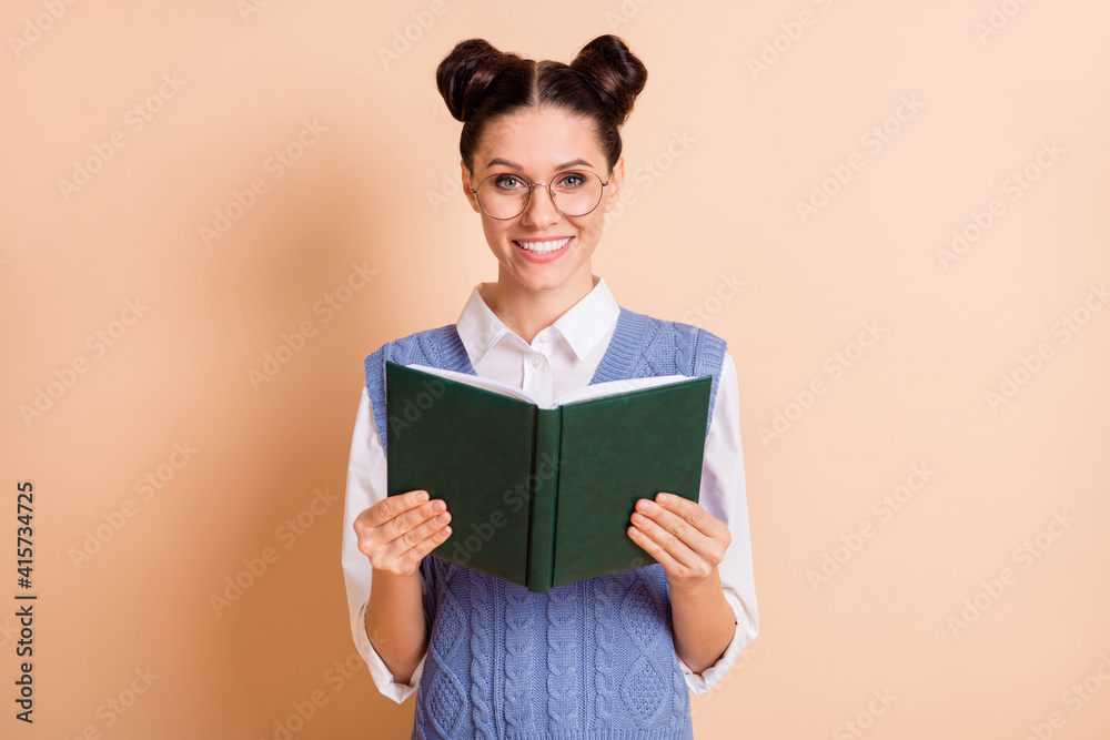 Photo of brunette optimistic lady read book wear spectacles white shirt blue vest isolated on beige color background Photo of brunette optimistic lady read book wear spectacles white shirt blue vest isolated on beige color background