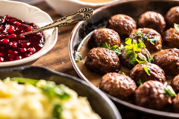 Swedish food Kottbullar meatballs, served in a pan with mashed potatoes, parsley and cranberry sauce