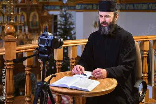 Fototapeta . An Orthodox priest is recording a video for his blog. Preaching during a pande