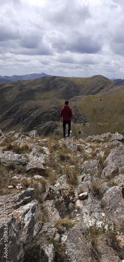 Naklejka premium boy standing looking at the landscape after climbing a mountain 